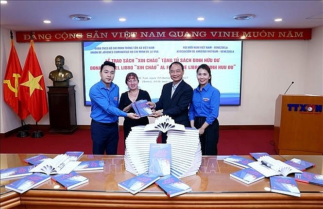 សមមិត្ត Le Duy Truyen អតីតអគ្គនាយករង VNA អនុប្រធានសមាគមមិត្តភាពវៀតណាម-វ៉េណេស៊ុយអេឡា និងជាទីប្រឹក្សាស្ថានទូតវេណេស៊ុយអេឡាប្រចាំនៅវៀតណាម Cora Fernandez ប្រគល់សៀវភៅ “ជំរាបសួរ” ដល់សម្ព័ន្ធយុវជនរបស់ទីភ្នាក់ងារសារព័ត៌មានវៀតណាម