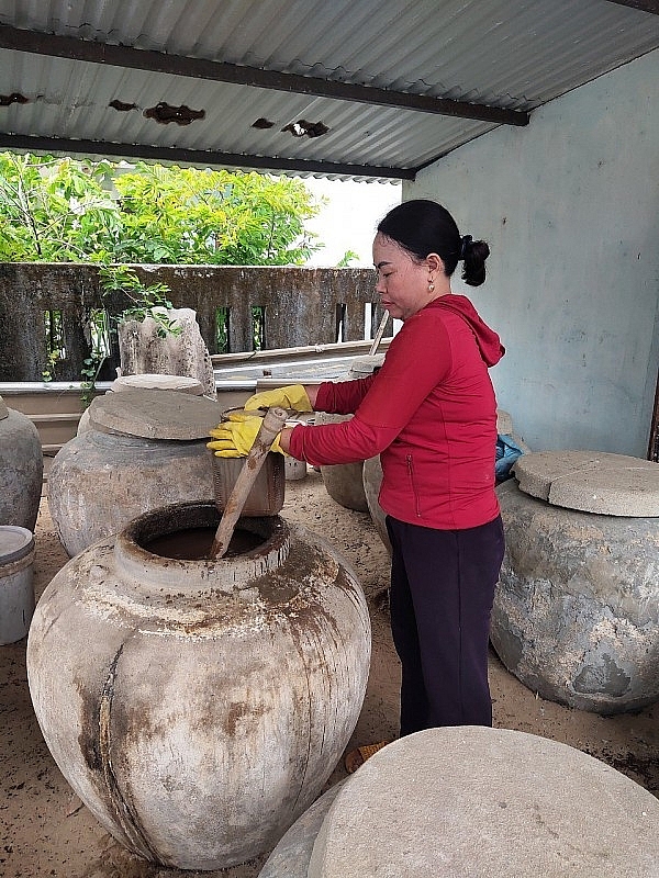 លោកស្រី Nguyen Thi Hoi ពិនិត្យ​ទឹក​ត្រី​ជប់​របស់​គ្រួសារ​គាត់។