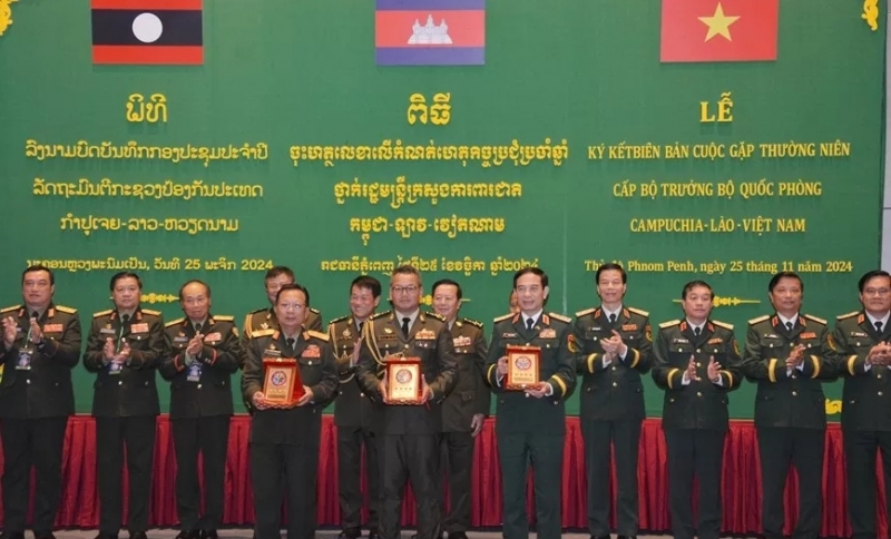 លោកនាយឧត្តមសេនីយ៍ Phan Van Giang លោកនាយឧត្តមសេនីយ៍ Chansamone Chanyalath និងលោកនាយឧត្តមសេនីយ៍ ទៀ សីហា នៅក្នុងពិធីចុះហត្ថលេខាលើកំណត់ហេតុកិច្ចប្រជុំប្រចាំឆ្នាំថ្នាក់រដ្ឋមន្ត្រីក្រសួងការពារជាតិ វៀតណាម-ឡាវ-កម្ពុជា